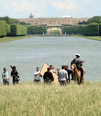 le tournage d'un film d'époque dans le parc du château de versailles.