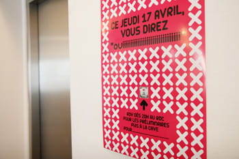 l'affiche d'une soirée corporate à côté des ascenseurs.