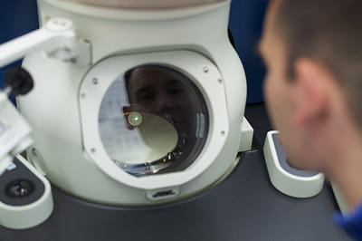 chercheur d'ibm se penchant sur un microscope électronique nanométrique du